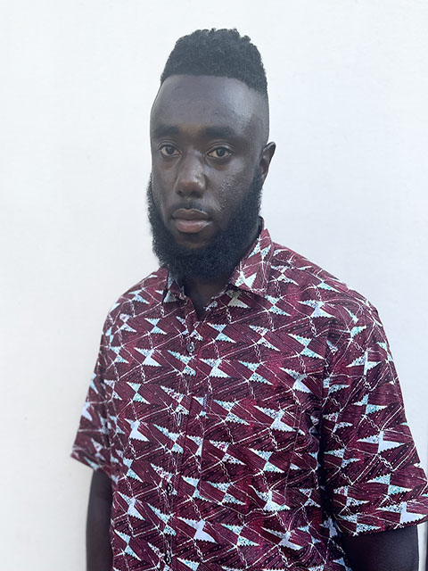Doctoral Researcher Keon Richardson wearing a red and white patterned shirt against a light background